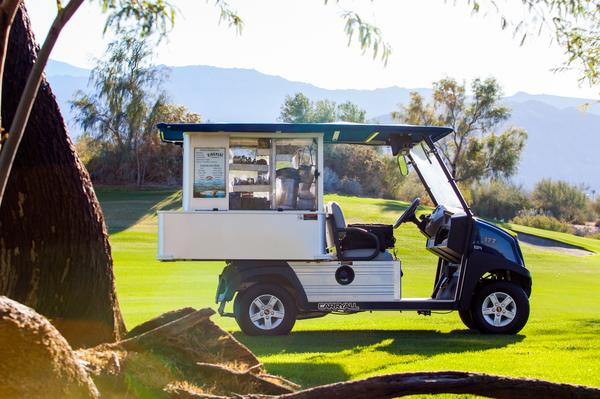 Ein Elektro Mini Food truck steht auf einem Golfplatz.