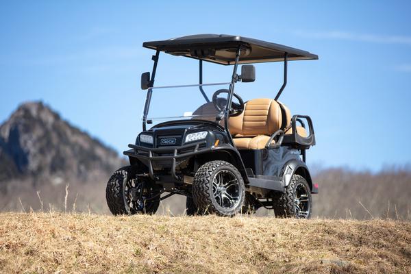 En Onward-golfvogn fra Club Car i Lifted-versionen er parkeret på et åbent område.