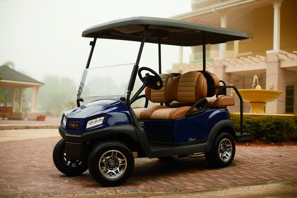 Tempo 2+2 golfvogn fra Club Car parkeret foran en bygning.