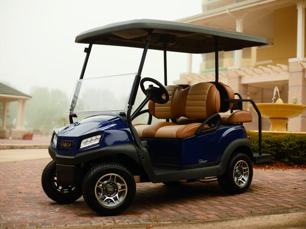 Tempo 2+2 golfvogn fra Club Car parkeret foran en bygning.